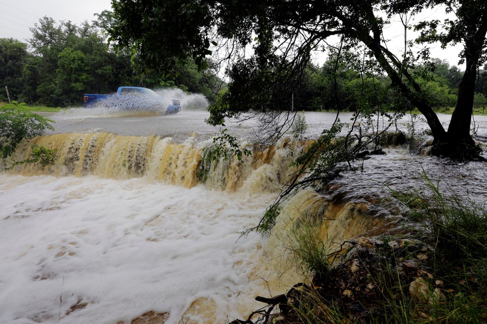A motorist passes through a low-water crossing near New Braunfels, Texas, June 2, 2016. (Photo by Eric Gay/AP)