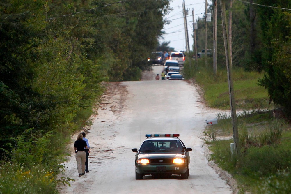 Officials walk along NW 29th Terrace near the scene of a shooting on Sept. 18, 2014 in Bell, Fla.