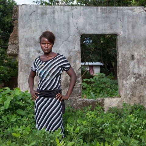 Mabinti Jawara, abducted by rebels at the age of 12, near the remains of her family's home that was destroyed during the war, Sierra leone.