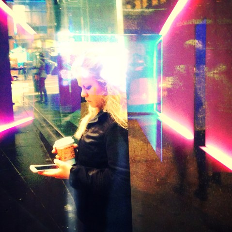 A woman checks her phone on the street in New York City.