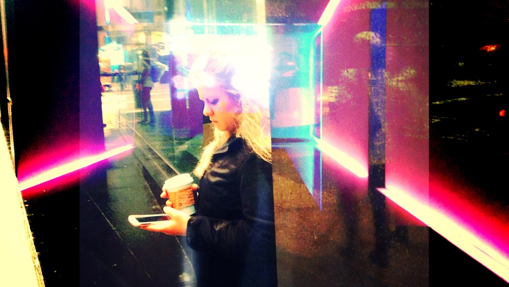 A woman checks her phone on the street in New York City.
