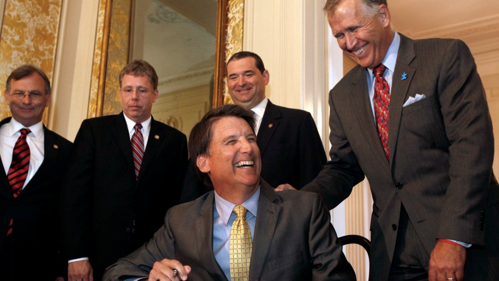 Gov. Pat McCrory, flanked by members of the N.C. General Assembly like Speaker of the House Thom Tillis, right, jokes before he signs the HB 998 for Tax Reform in the ballroom at the Executive Mansion in Raleigh, N.C. on Tuesday, July 23, 2013. (AP...