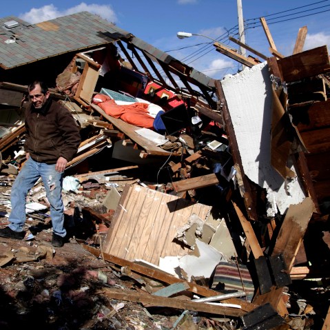 James Traina climbs over the remains of his parent's house which was destroyed by Superstorm Sandy in Staten Island, N.Y. Friday, Nov. 2, 2012. (AP Photo/Seth Wenig)
