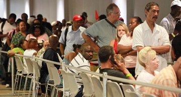 People wait in line to attend a free health care clinic for the uninsured.