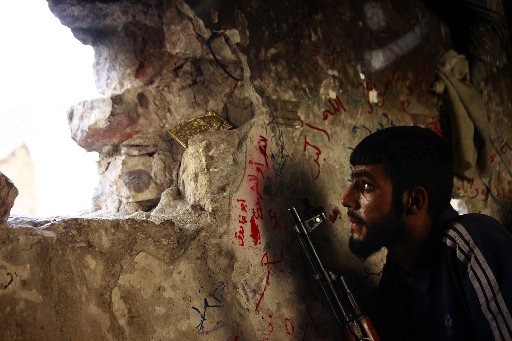 Image: A Free Syrian Army fighter sits on a lookout for forces loyal to Syrian President Bashar Al-Assad in Ogiwl