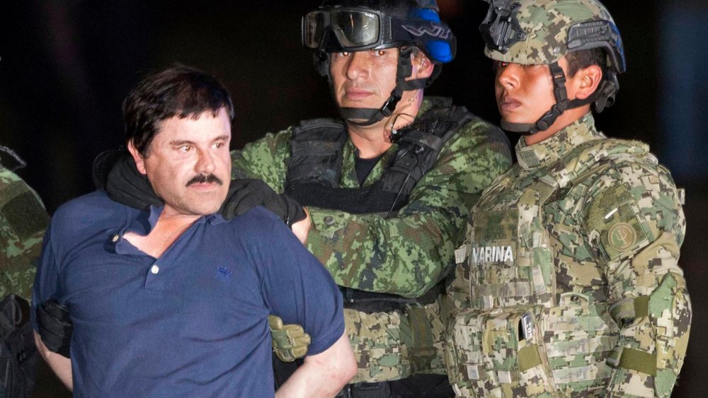 In this Friday, Jan. 8, 2016 photo, Joaquin "El Chapo" Guzman is made to face the press as he's escorted to a helicopter in handcuffs by soldiers and marines at a federal hangar in Mexico City. (Photo by Eduardo Verdugo/AP)