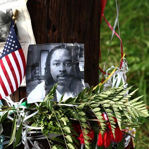 Photos of Samuel DuBose hang on a pole at a memorial, July 29, 2015 in Cincinnati, near where he was shot and killed by a University of Cincinnati police office. (Photo by Tom Uhlman/AP)
