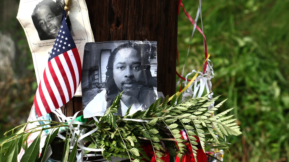 Photos of Samuel DuBose hang on a pole at a memorial, July 29, 2015 in Cincinnati, near where he was shot and killed by a University of Cincinnati police office. (Photo by Tom Uhlman/AP)