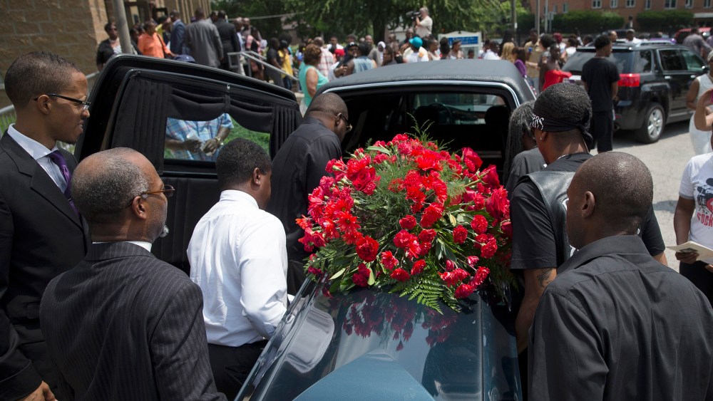 The casket of Samuel Dubose is transported to a hearse during his funeral at the Church of the Living God in the Avondale neighborhood of Cincinnati, July 28, 2015. (Photo by John Minchillo/AP)