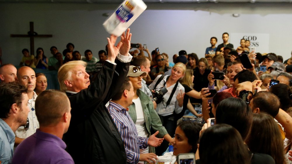 Image: U.S. President Trump tosses rolls of paper towels to people at a hurricane relief distribution center at Calvary Chapel in San Juan