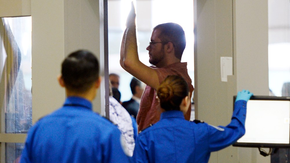 An airline passenger stands in a full-body scanner at Transportation Security Administration checkpoint at Los Angeles International Airport