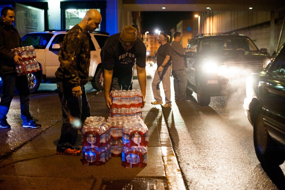 Lines of cars formed around the block as pallets of bottled water were being brought and distributed in downtown Charleston, West Virginia, Jan. 10, 2014.