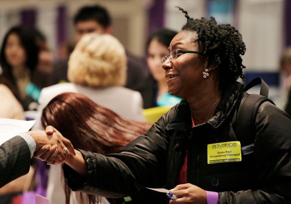Susan Paul, who has recently completed a Masters program in occupational therapy, shakes hands with a recruiter at a healthcare job fair, Thursday, March 14, 2013, in New York. (Photo by Mark Lennihan/AP)