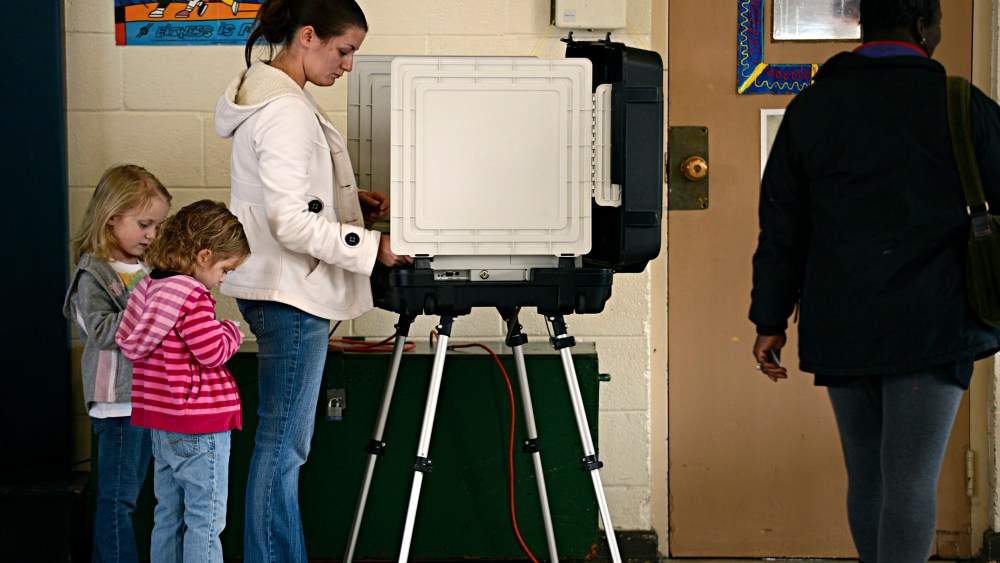 Ashley Zorman votes while her daughters Erica Zorman, left, and Keira Zorman, look on at Little Creek Elementary School in Norfolk, Va.  on Tuesday, Nov.  6, 2012.