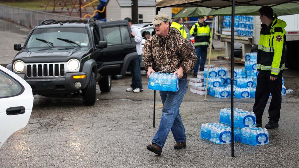 Members of the Nitro Volunteer Fire Department help to distribute bottled water to local residents Saturday Jan. 11, 2014.