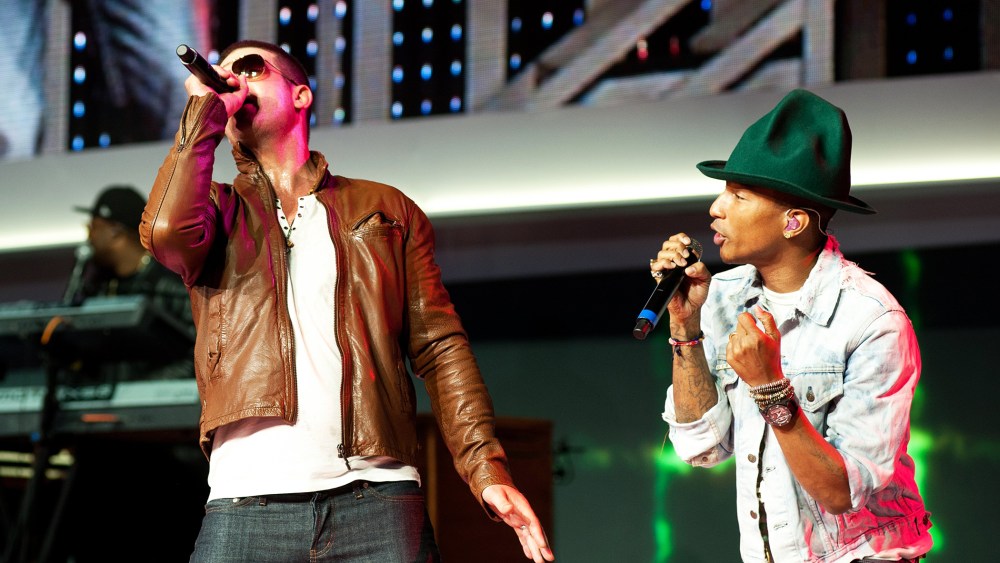 Robin Thicke, left, performs on stage with Pharrell Williams, at the annual Wal-Mart Shareholders meeting in Fayetteville, Ark., June 6, 2014.