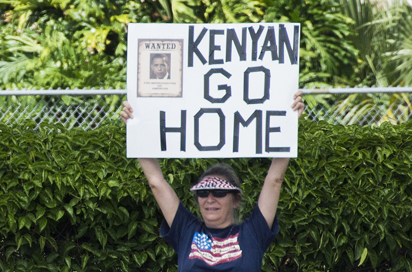 Protesters hold up placards as the president's motorcade passes by in Orlando, Forida, August 10, 2013. (Photo by Jim Watson/Getty Images)