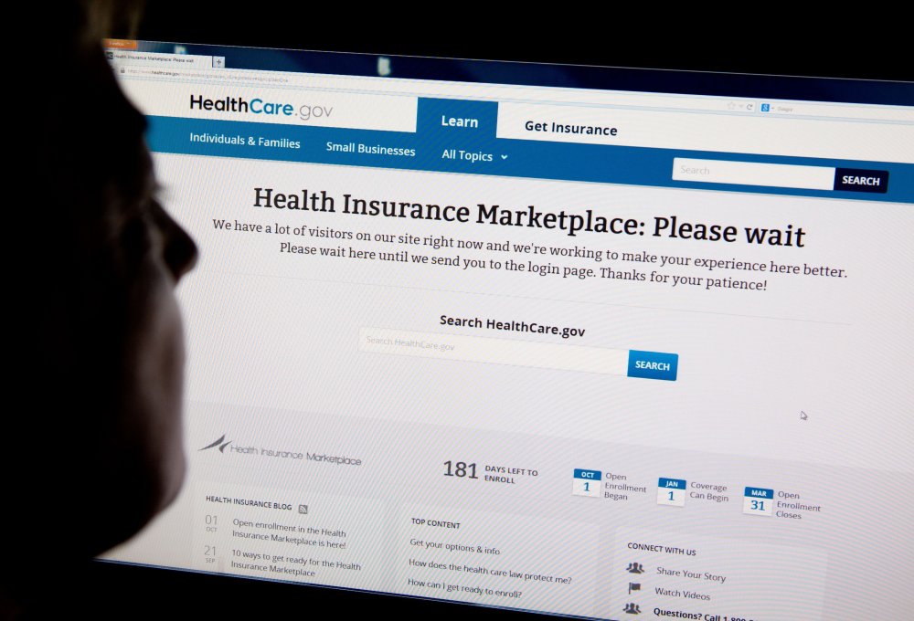 A woman looks at the HealthCare.gov insurance exchange internet site showing a "Please wait" page, in this October 1, 2013 file photo in Washington, DC.
