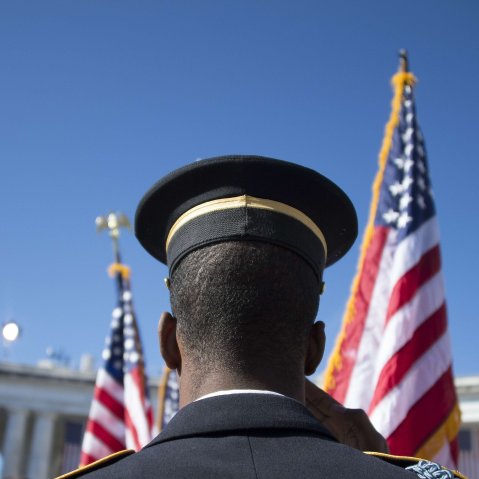 A member of the US Army Honor Guard salutes as the colors are presented during a Veteran's Day ceremony at Arlington National Cemetery in Arlington, Va. on Nov. 11, 2013.