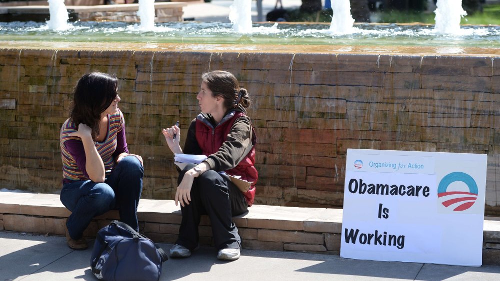 An Affordable Healthcare Act supporter (R) talks with a student (L) about the law on the campus of Santa Monica City College in Santa Monica, California, October 10, 2013.