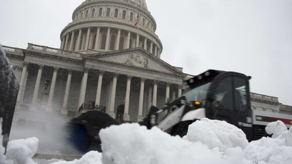 A snow plow passes by pushing away slush outside the U.S. Capitol Building in Washington, D.C., December 10, 2013.