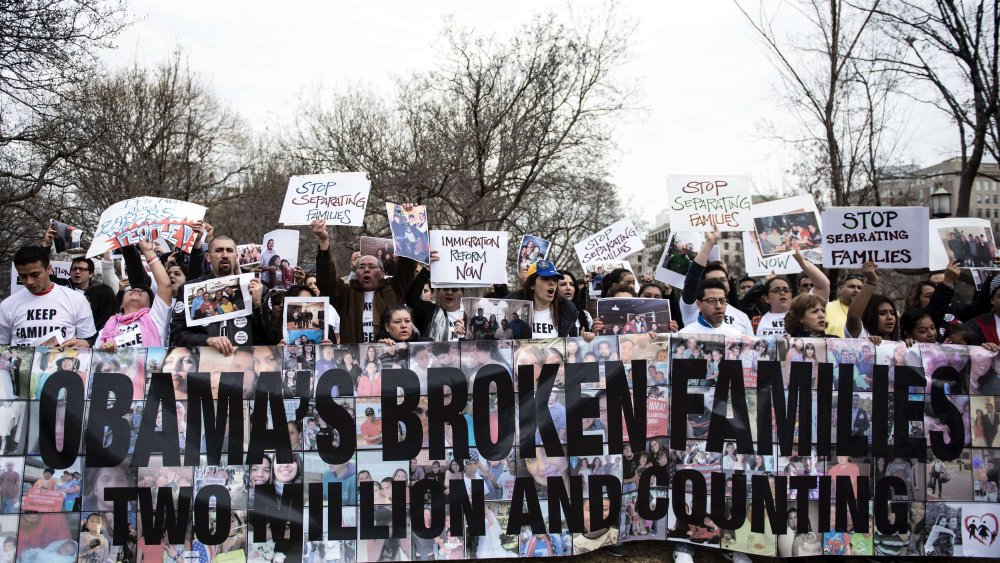 Activists hold signs and family photos in Lafayette Square outside the White House March 12, 2014 in Washington, D.C.