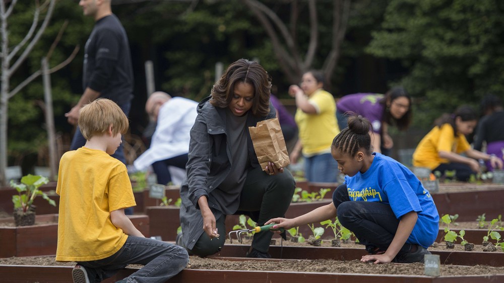 US First Lady Michelle Obama plants with students from Friendship Public Charter Elementary in the White House Kitchen Garden at the White House in Washington, DC, on April 2, 2014.
