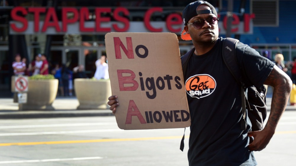 A man carries a message as people gathered to protest outside Staples Center, April 29, 2014 in Los Angeles, California.