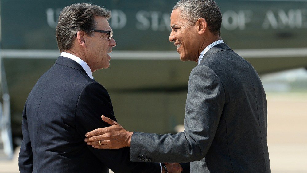 US President Barack Obama is greeted by Texas Governor Rick Perry as he arrives in Dallas, Texas, on July 9, 2014