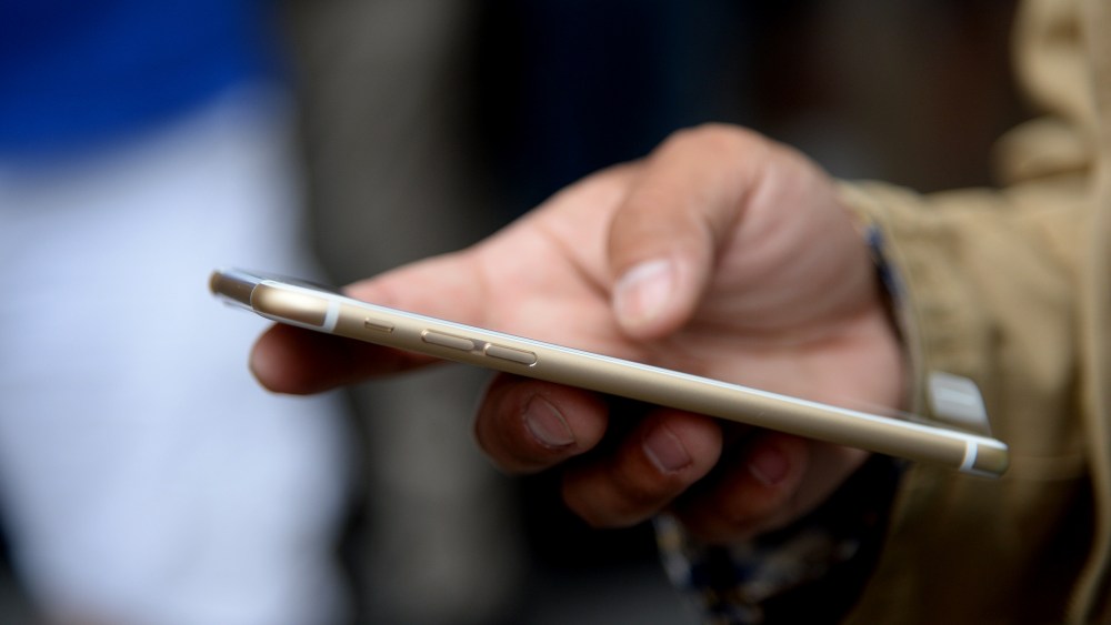 A customer checks out his new iPhone 6 Plus outside the Apple store in Pasadena, Calif. on the first day of sale, Sept. 19, 2014.