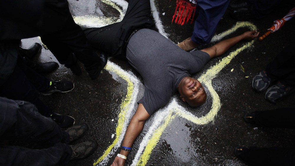 Pastor Charles Burton has his body outlined with chalk to replicate a crime scene as he and other demonstrators protest the shooting of Michael Brown outside the Ferguson Police Station on Oct. 13, 2014 in Ferguson, Mo.