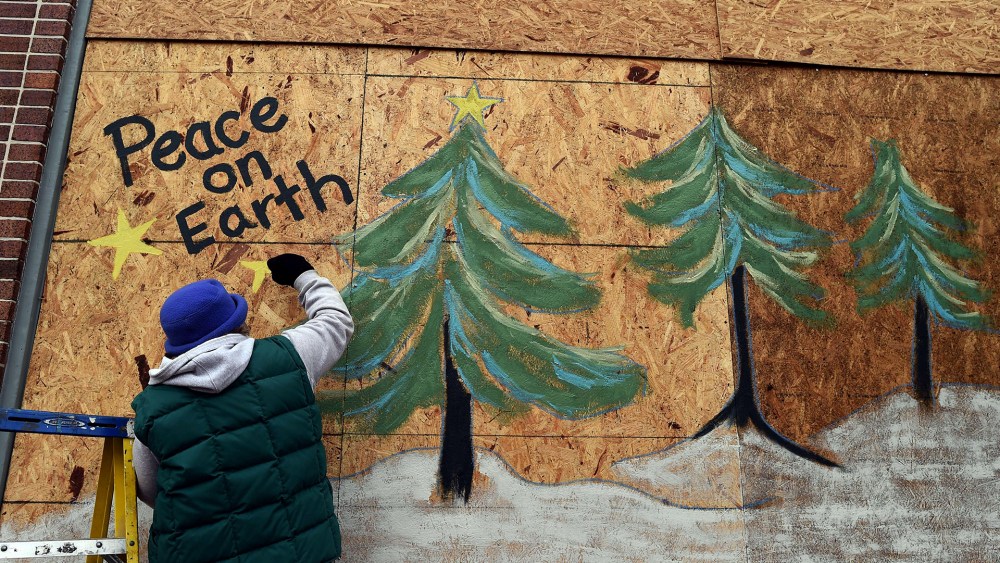 Karen Gold paints on a boarded window of her store in Ferguson, Missouri, on Nov. 26, 2014.