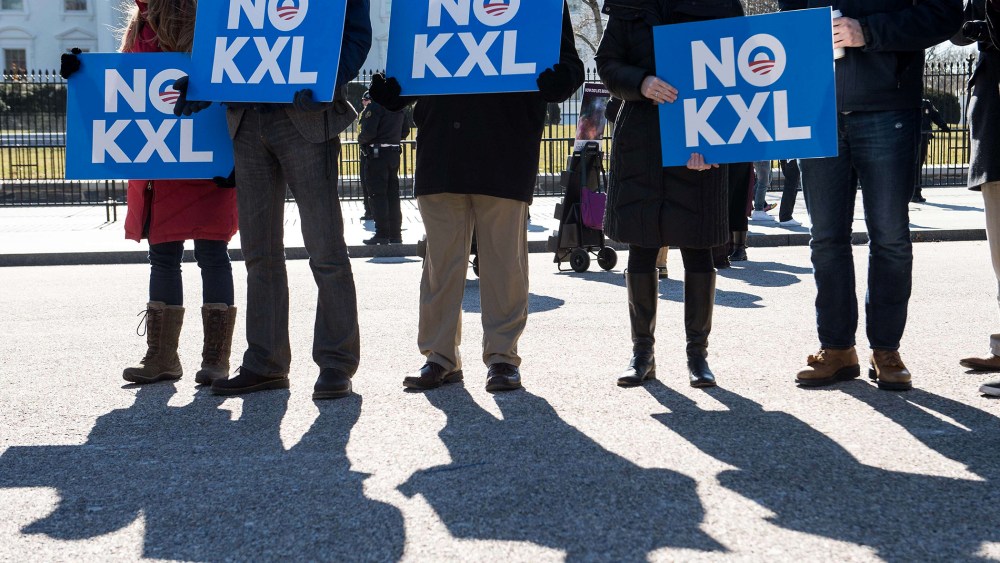 Demonstrators hold signs against the proposed Keystone XL pipeline from Canada to the Gulf of Mexico in front of the White House in Washington, DC. on Feb, 24, 2015.