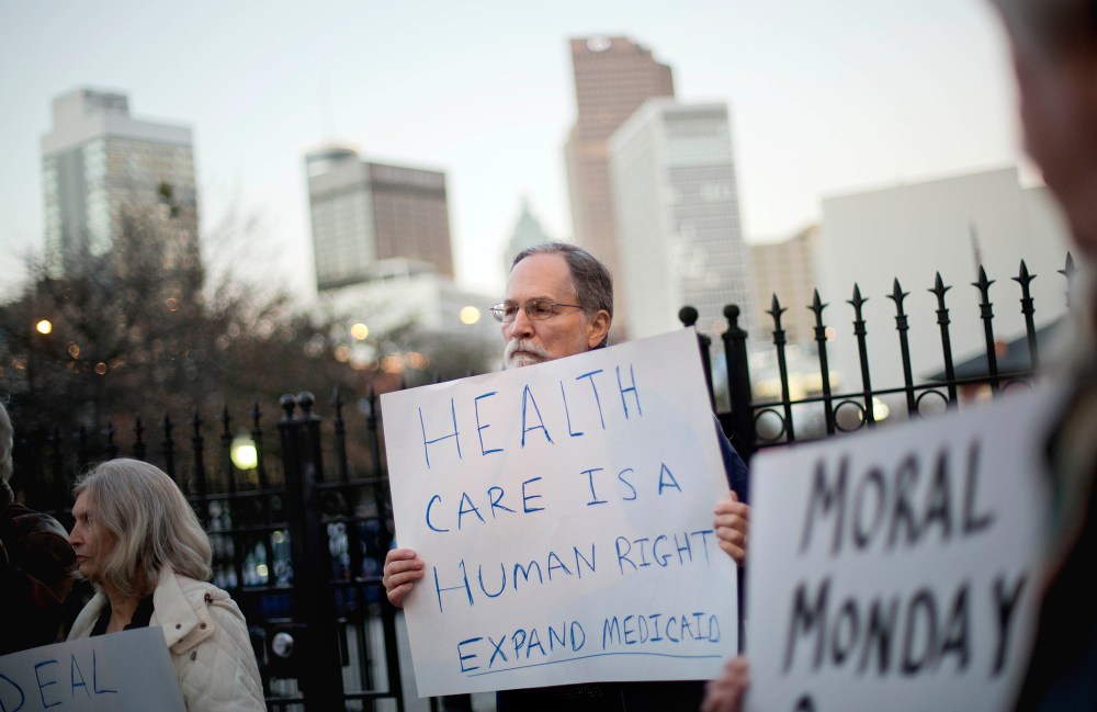 Bert Skellie, of Decatur, Ga., protests for Medicaid expansion outside the Wild Hog Supper, Sunday, Jan. 12, 2014, in Atlanta.