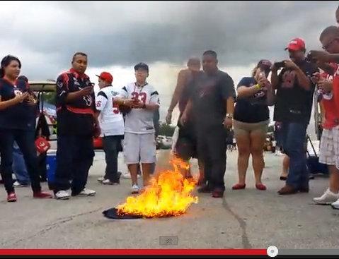 A frame from a YouTube video showing an angry football fan spend way too much money to perform a symbolic act of destruction that doesn't actually do anything about the thing he's angry about.