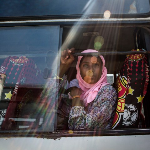 A Rohingya girl sits on a bus as relocated to their new temporary shelter on May 13, 2015 in Lhoksukon, Aceh province, Indonesia. (Photo by Ulet Ifansasti/Getty)
