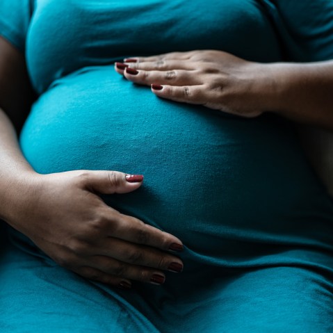 Pregnant woman touching her belly