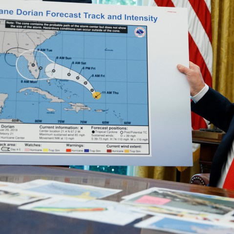 Donald Trump holds a NOAA map.