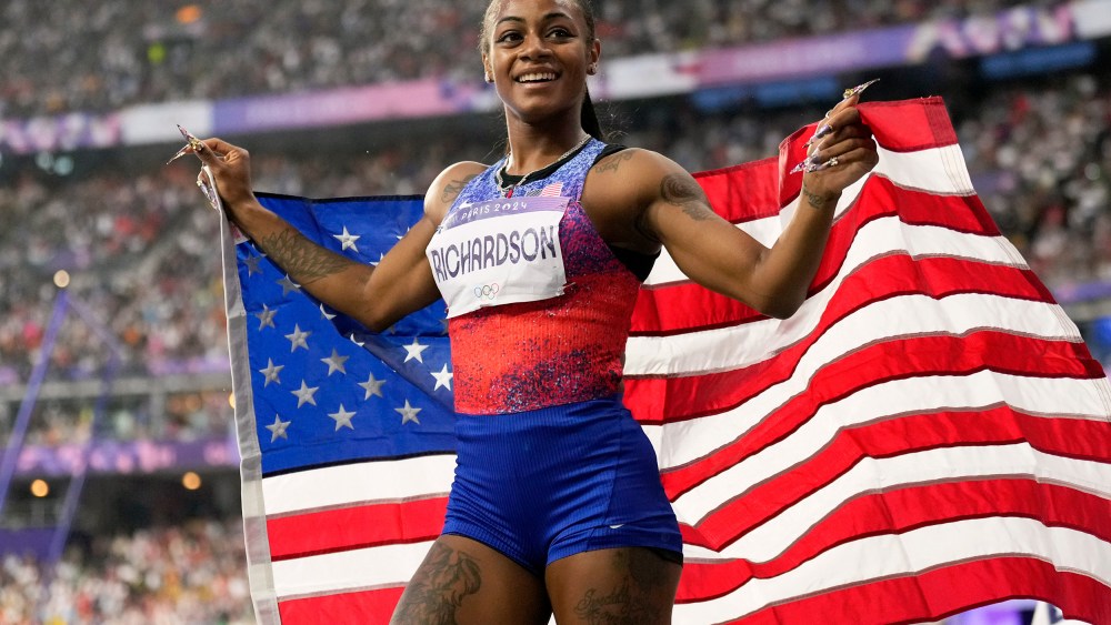 Sha'carri Richardson holds the U.S. flag.