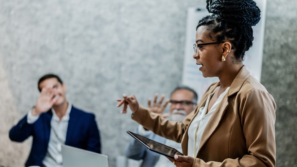 Businesswoman talking with coworkers in business meeting at office