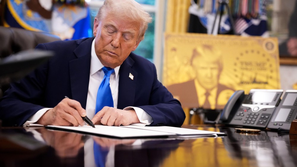President Donald Trump signs an executive order in the Oval Office on Sept. 19, 2025 ,establishing the “Trump Gold Card” and introducing a $100,000 fee for H-1B visas.