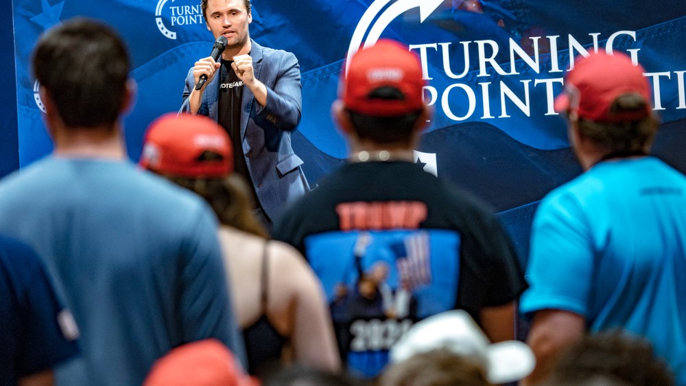 Charlie Kirk speaks in front of an audience on stage