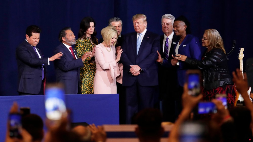 Pastor Paula White, third from left, and other faith leaders pray with President Donald Trump.