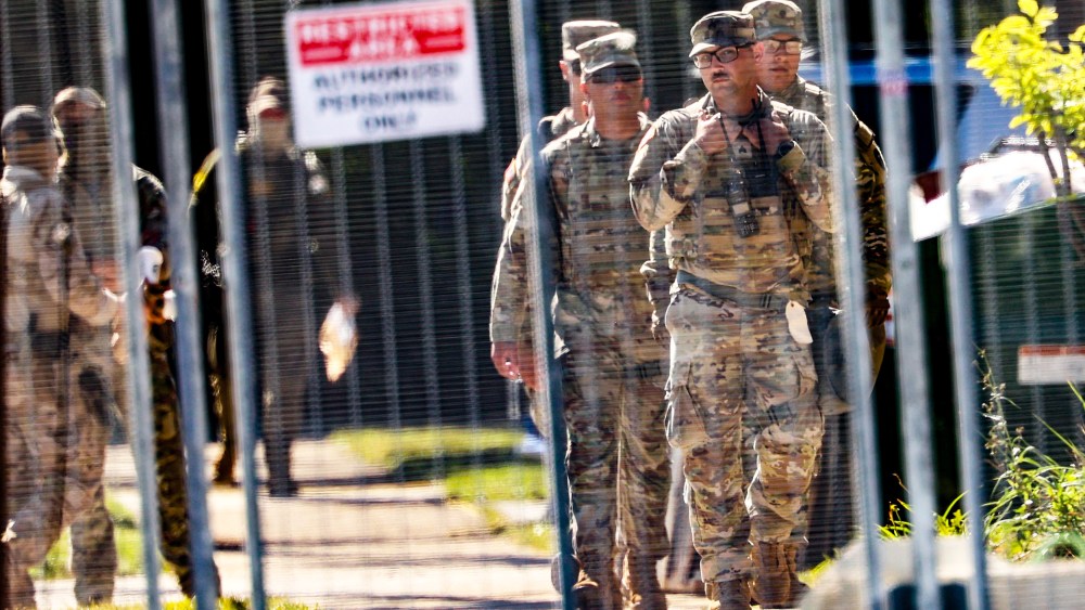 National Guard members walk around outside of the U.S. Immigration and Customs Enforcement holding facility.