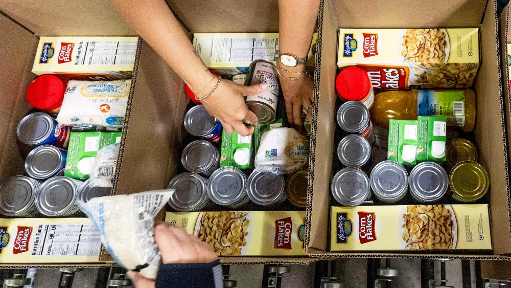 Workers pack boxes at The Orange County Food Bank.