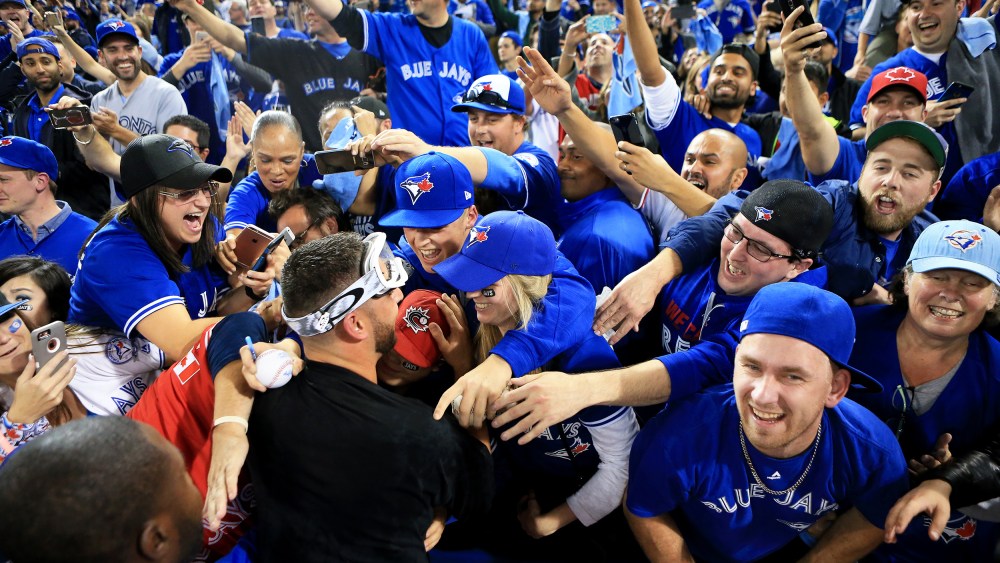 Marco Estrada #25 of the Toronto Blue Jays is swarmed by fans in Toronto, Canada.