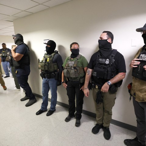 Federal agents wait in the hallway outside of a courtroom in NYC.