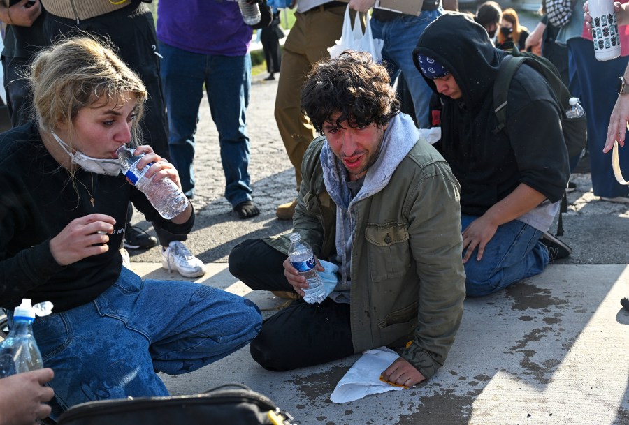 Demonstrators protesting outside the U.S Immigration & Customs Enforcement facility, including Democratic congressional candidate Kat Abughazaleh, left, react after being tear-gassed in Broadview, IL.