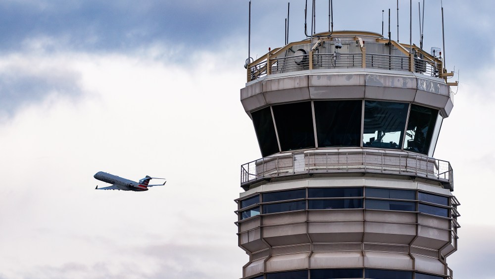 An American Eagle plane takes off near the air traffic control tower.