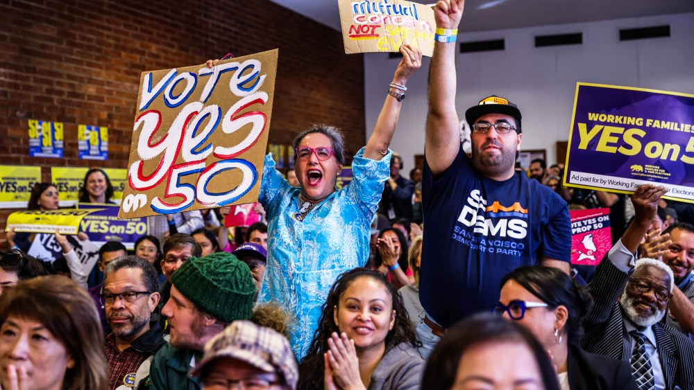 People cheer during a campaign event in support of Prop 50 in San Francisco.